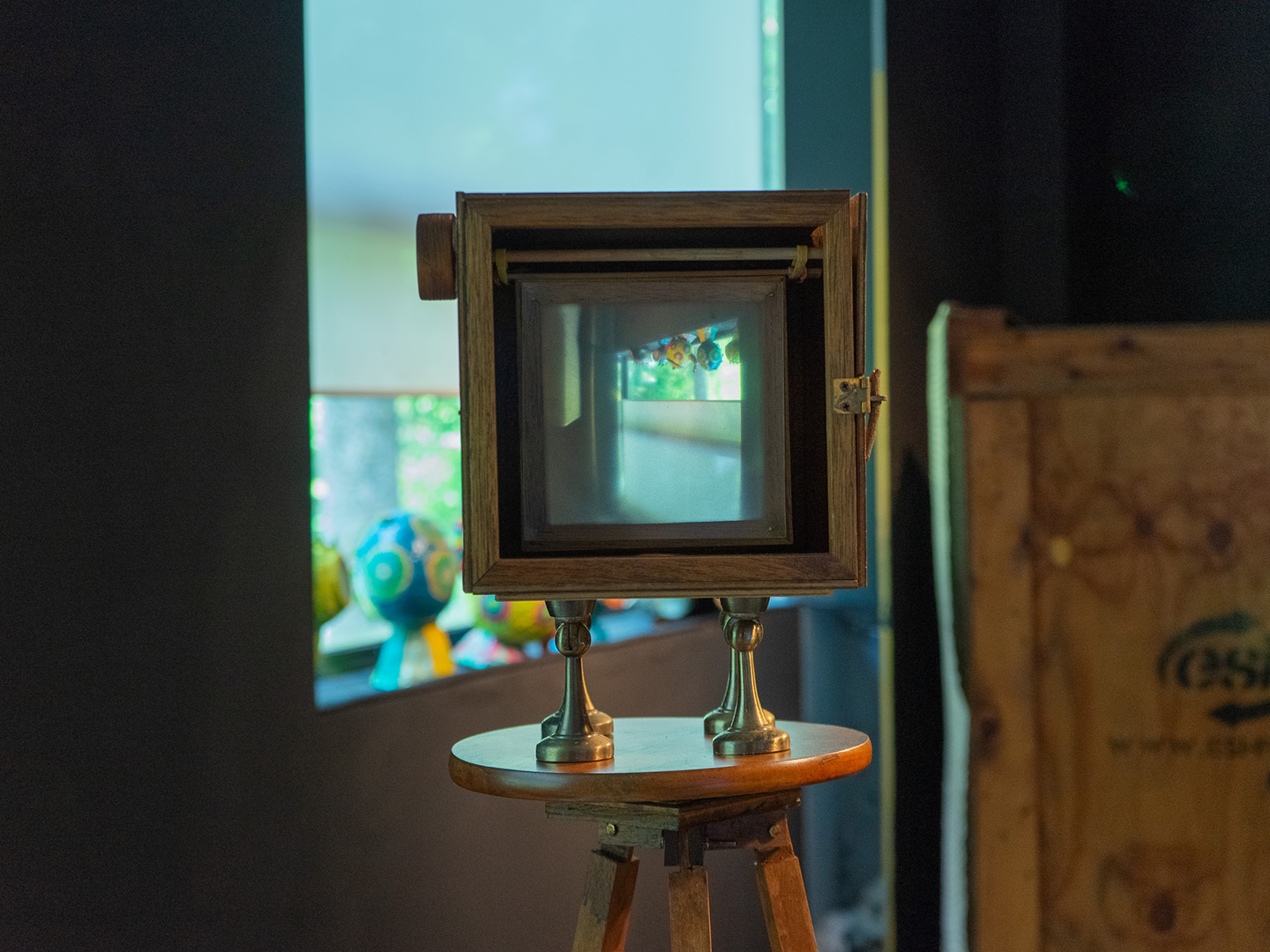 Isabelle Desjeux, The Wunderkamera, 2021, lens, plywood, frosted plastic, rubber bands, dowels, magnetic door stoppers, ball bearings, wooden tripod.