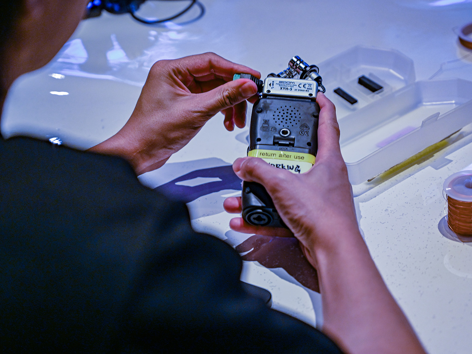 a hand holding a audio recording device.
