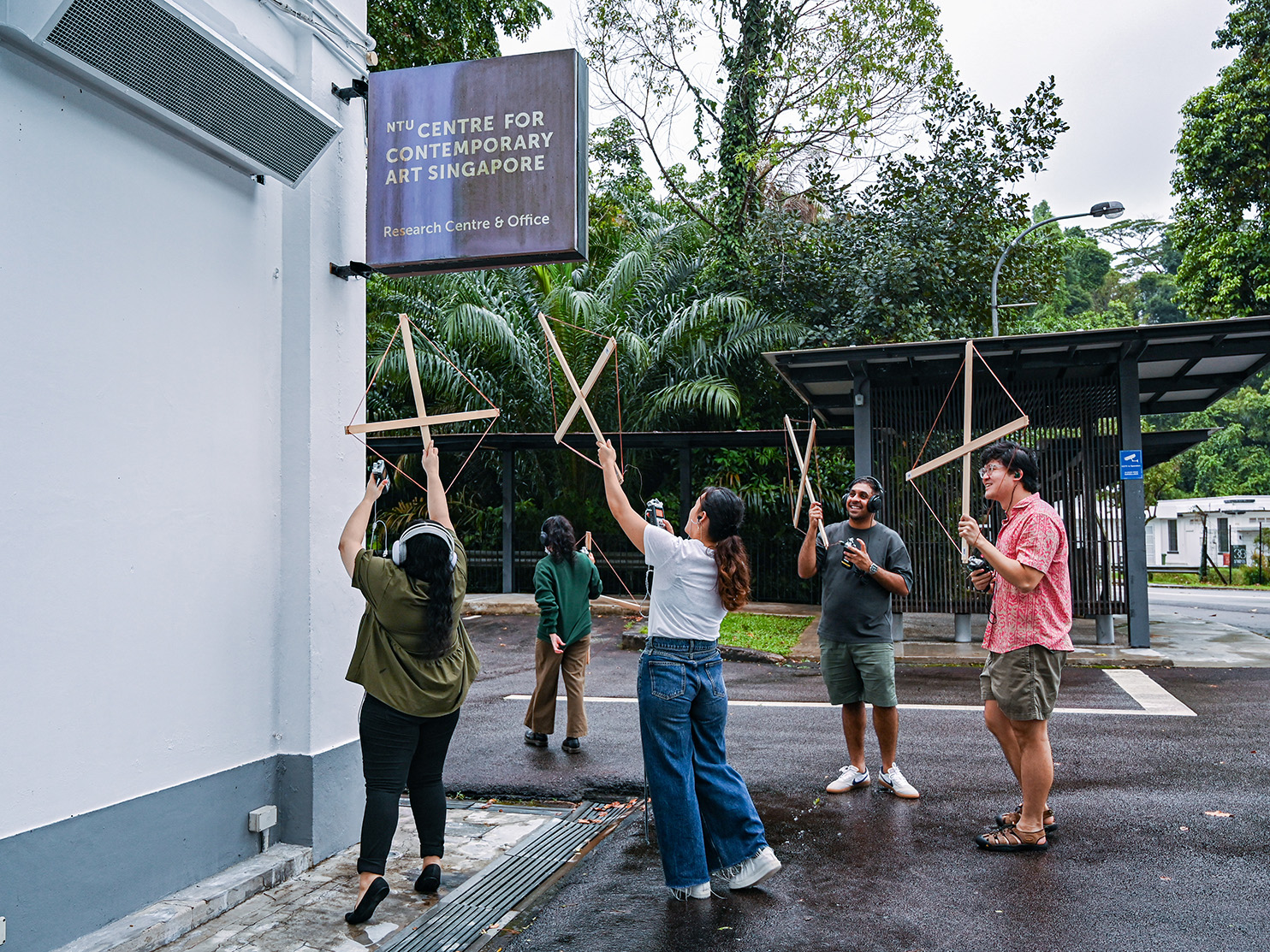 People with antennae listening to radio waves near a building