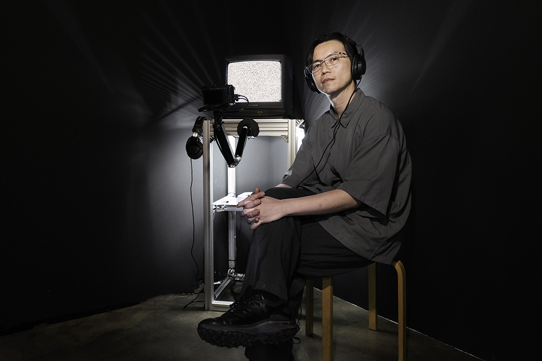 portrait of an artist in front of his television installation